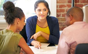 Couple Meeting With Financial Advisor In Office