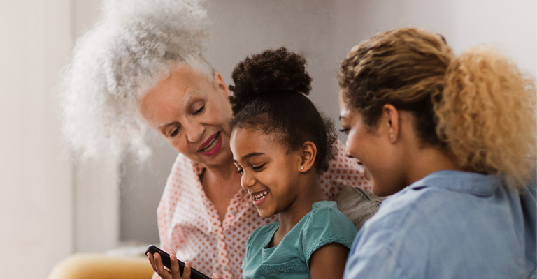 Granddaughter showing grandmother how to use smartphone